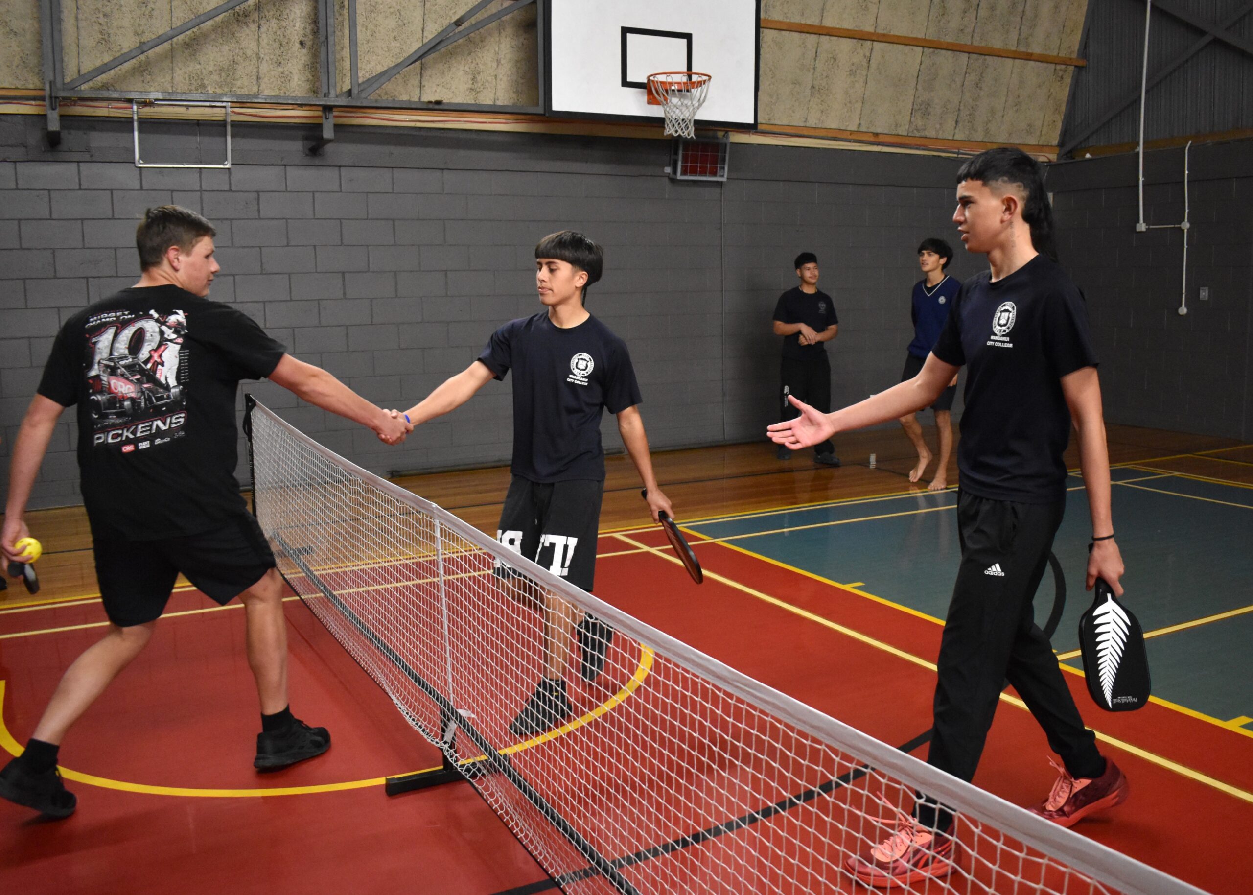 Cullinane and Whanganui City College pickleball players shake hands over the net after their match at Kura Wars 2024.